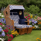 Strandkorb Trendy Trend 45 mit Bullaugen, PE walnut, Dessin 743 blau weiss kariert im blühenden Garten auf Rasenfläche