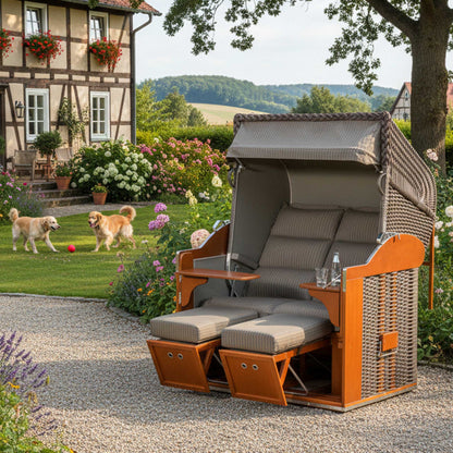 Strandkorb Classic 2-Sitzer cappuccino in einem blühenden Garten mit zwei Golden Retrievern.